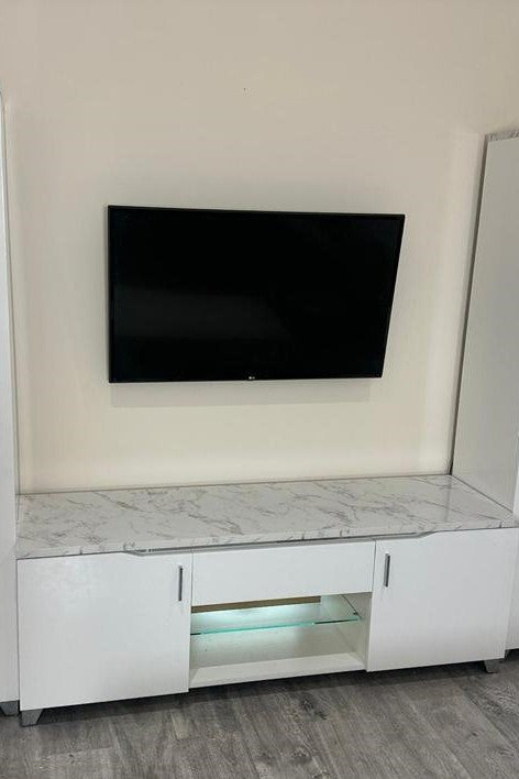 Modern entertainment console with a television mounted on the wall.