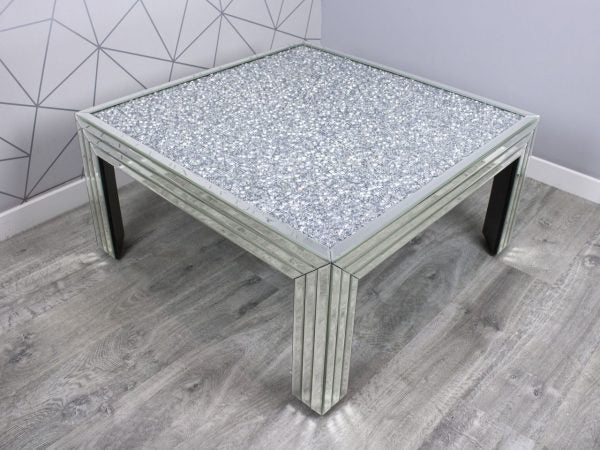 Coffee table with a glittery top in a room with geometric wall design.