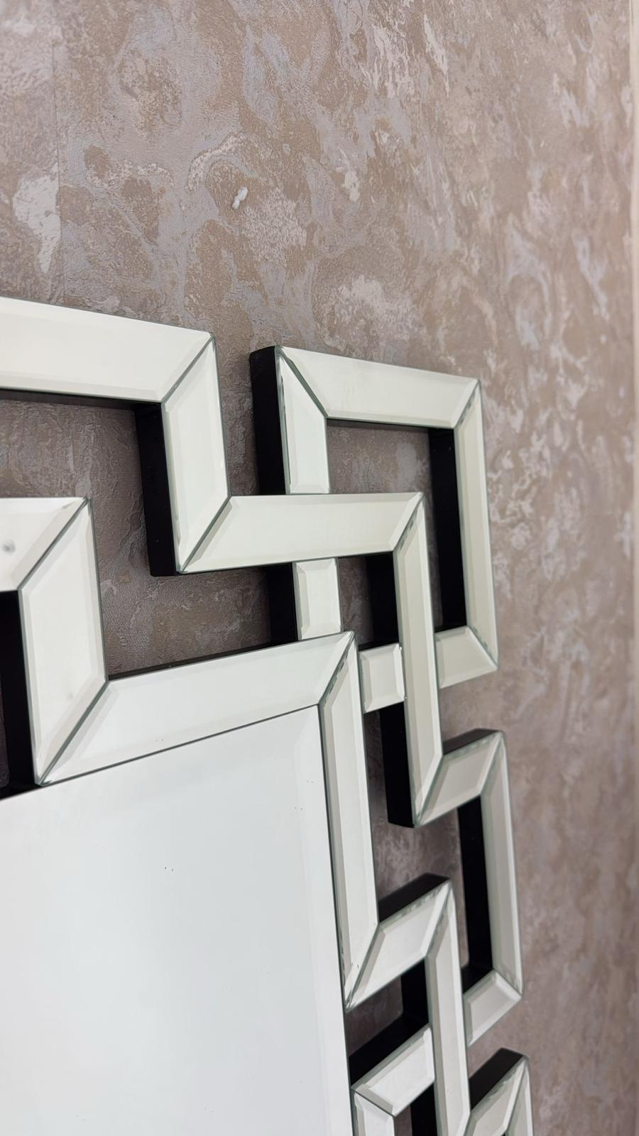 Decorative wall mirrors with geometric designs on a textured wall.