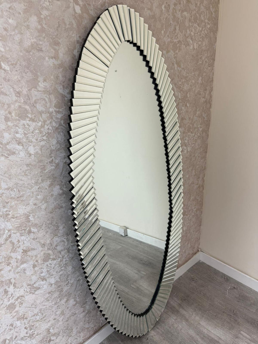 Oval mirror with decorative frame on a textured wall