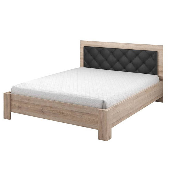 Wooden bed with black upholstered headboard on a white background