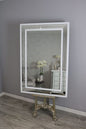 Decorative mirror with a white frame on a gray wall