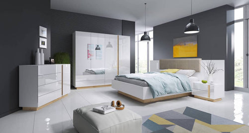 Modern bedroom with white furniture, gray walls, and a colorful rug.