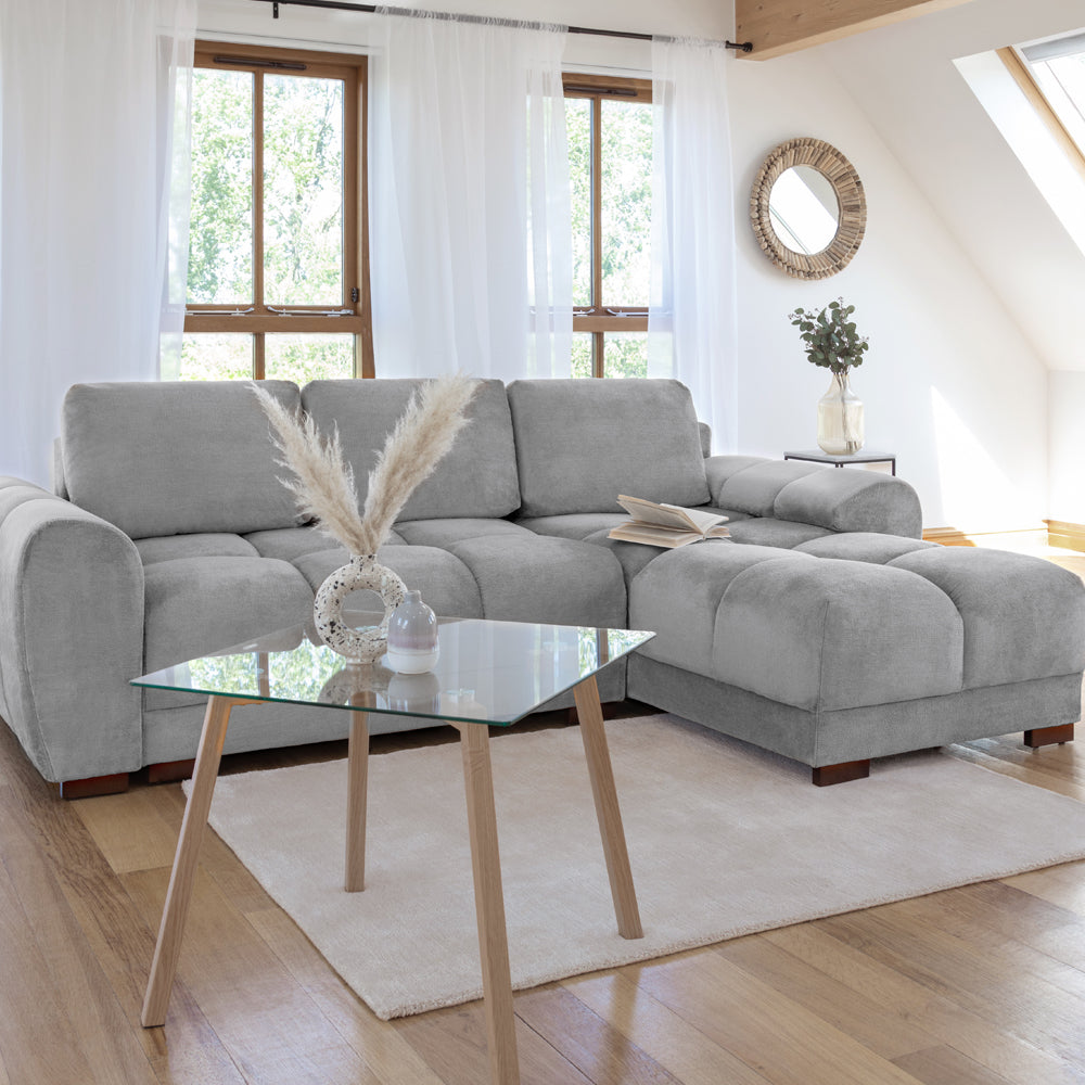 Gray sectional sofa in a living room with wooden coffee table and decorative items.