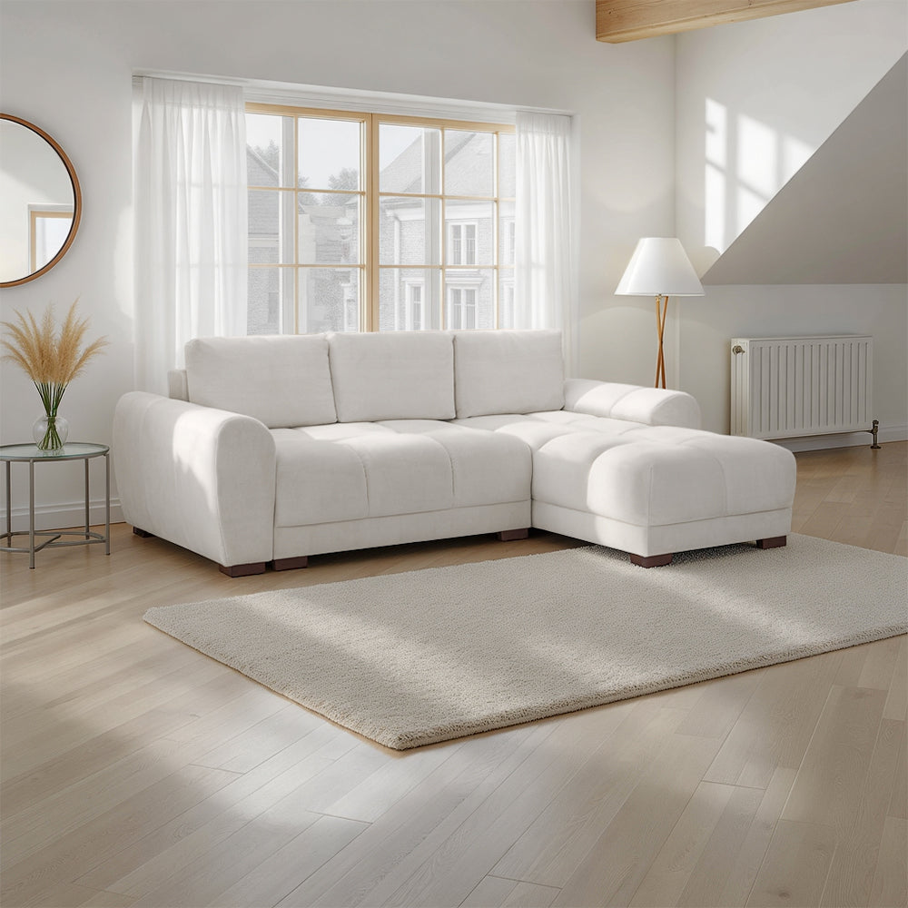 White sectional sofa in a bright living room with large windows.