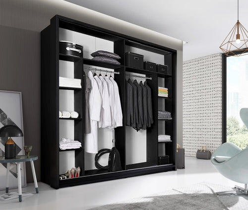 Modern black wardrobe with clothes in a stylish room