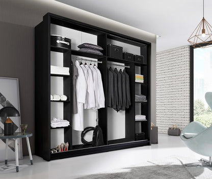 Modern black wardrobe with clothes in a stylish room