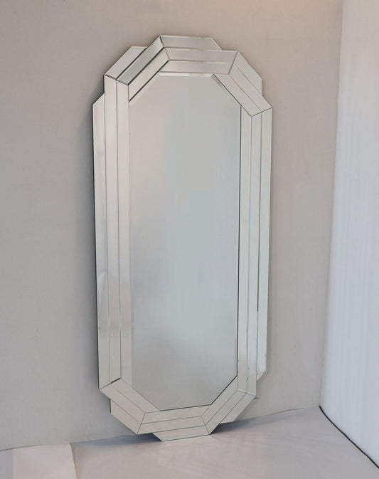 Octagonal mirror with decorative frame on a plain wall