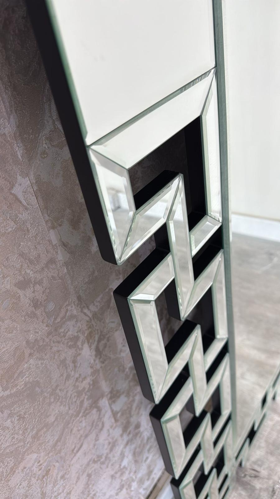 Decorative mirror with geometric pattern on a textured wall.