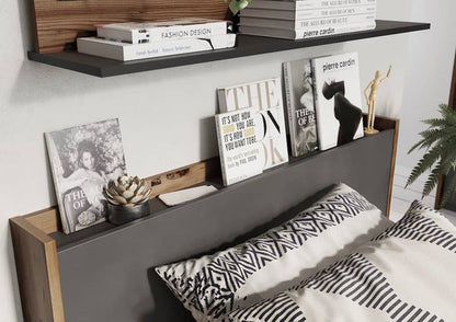 Bedroom with a headboard displaying books and decor items.