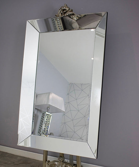 Decorative mirror with a decorative frame on a gray wall