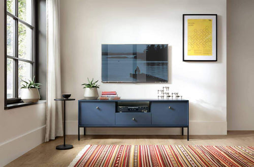 Modern living room with a blue entertainment console, TV, and decorative items.