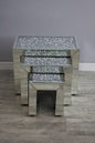 Set of three mirrored side tables with glittery surface on a wooden floor.