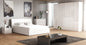 Modern bedroom with white furniture, including a bed and dresser, on a wooden floor.