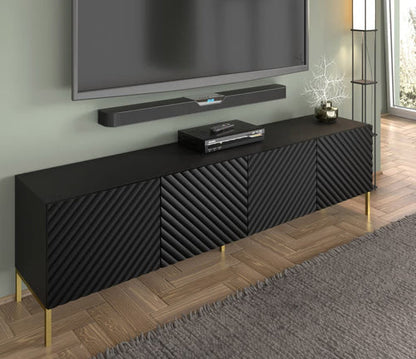 Black textured TV stand with gold legs in a room setting.