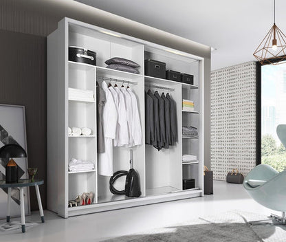 Modern wardrobe with clothes and shelves in a room with a chair and lamp.