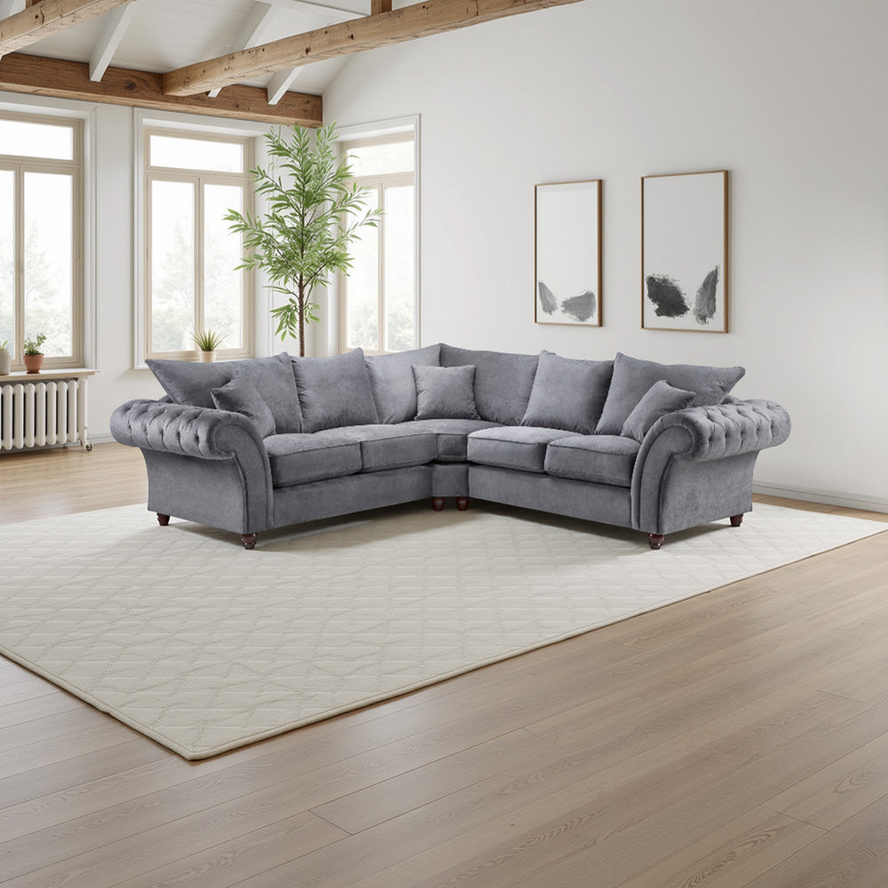 Gray sectional sofa in a bright living room with large windows and wooden beams.