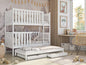 White bunk bed with pull-out trundle in a room with decor elements.