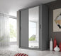 Gray sliding door wardrobe with mirror in a room with a window and decorative vases.