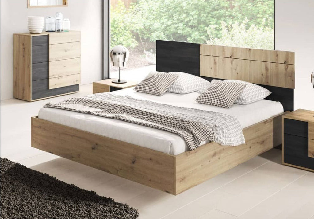 Wooden bed with black headboard in a bedroom setting
