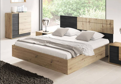 Wooden bed with black headboard in a bedroom setting