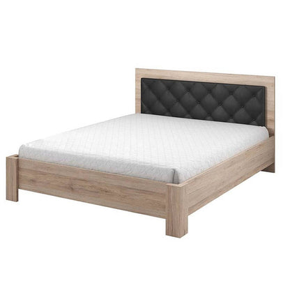 Wooden bed with black upholstered headboard on a white background